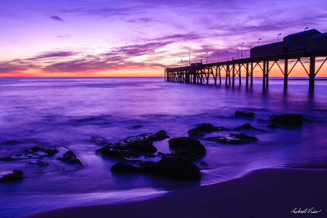 Catherine Hill Bay pier at dawn with purple sky, long-exposure ocean and rocky shoreline, by Australian landscape photographer Robert Vine