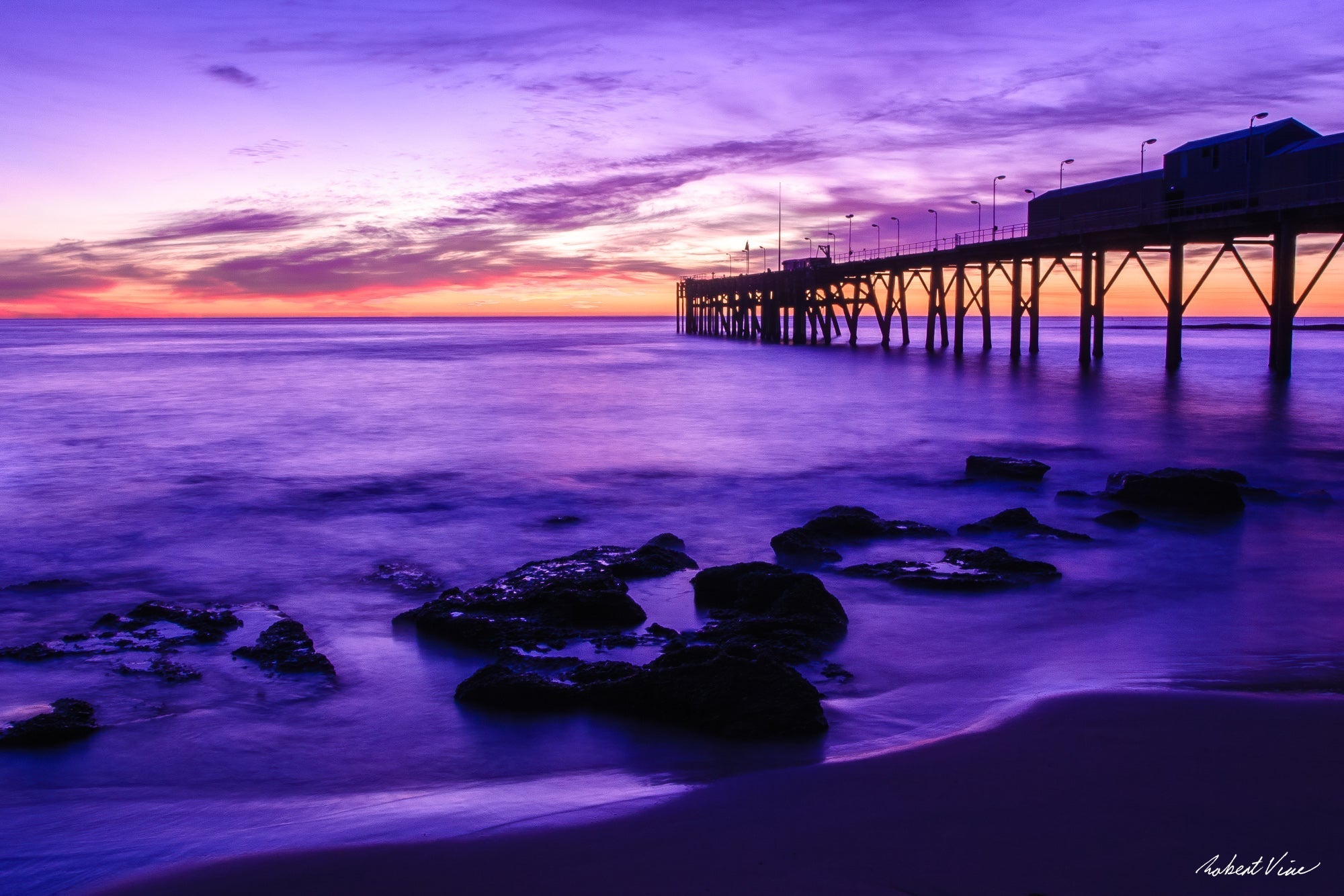 Catherine Hill Bay pier at dawn with purple sky, long-exposure ocean and rocky shoreline, by Australian landscape photographer Robert Vine