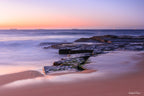 Fine art landscape photograph of Susan Gilmore Beach at sunrise — soft pastel sky over sandstone rocks and calm sea, Australian coastal landscape art print by Robert Vine.