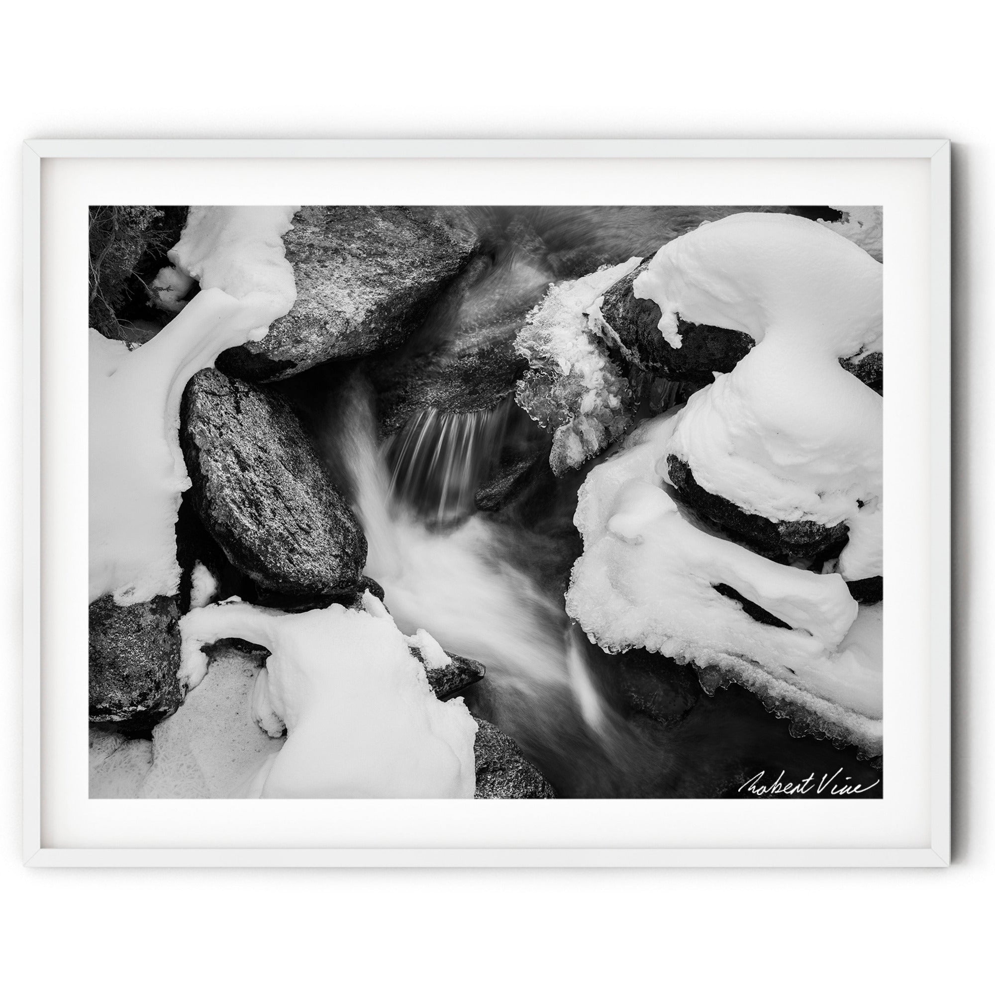 Black and white winter landscape art print of flowing water among snow-covered rocks — minimalist fine art photography for modern interiors.