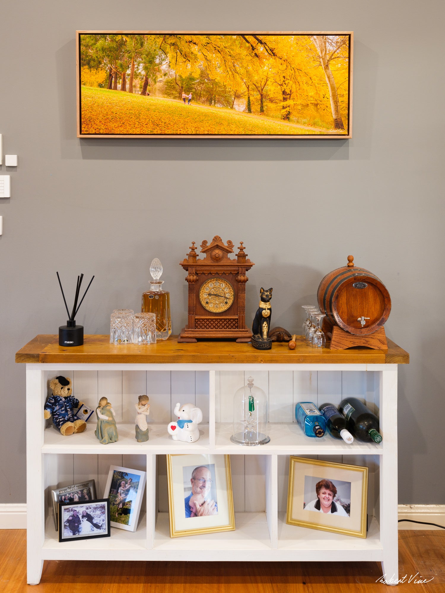40x108cm panoramic float mount canvas print by Robert Vine featuring brilliant golden autumn trees in a Canberra park, displayed in a contemporary home interior with a natural timber float frame.