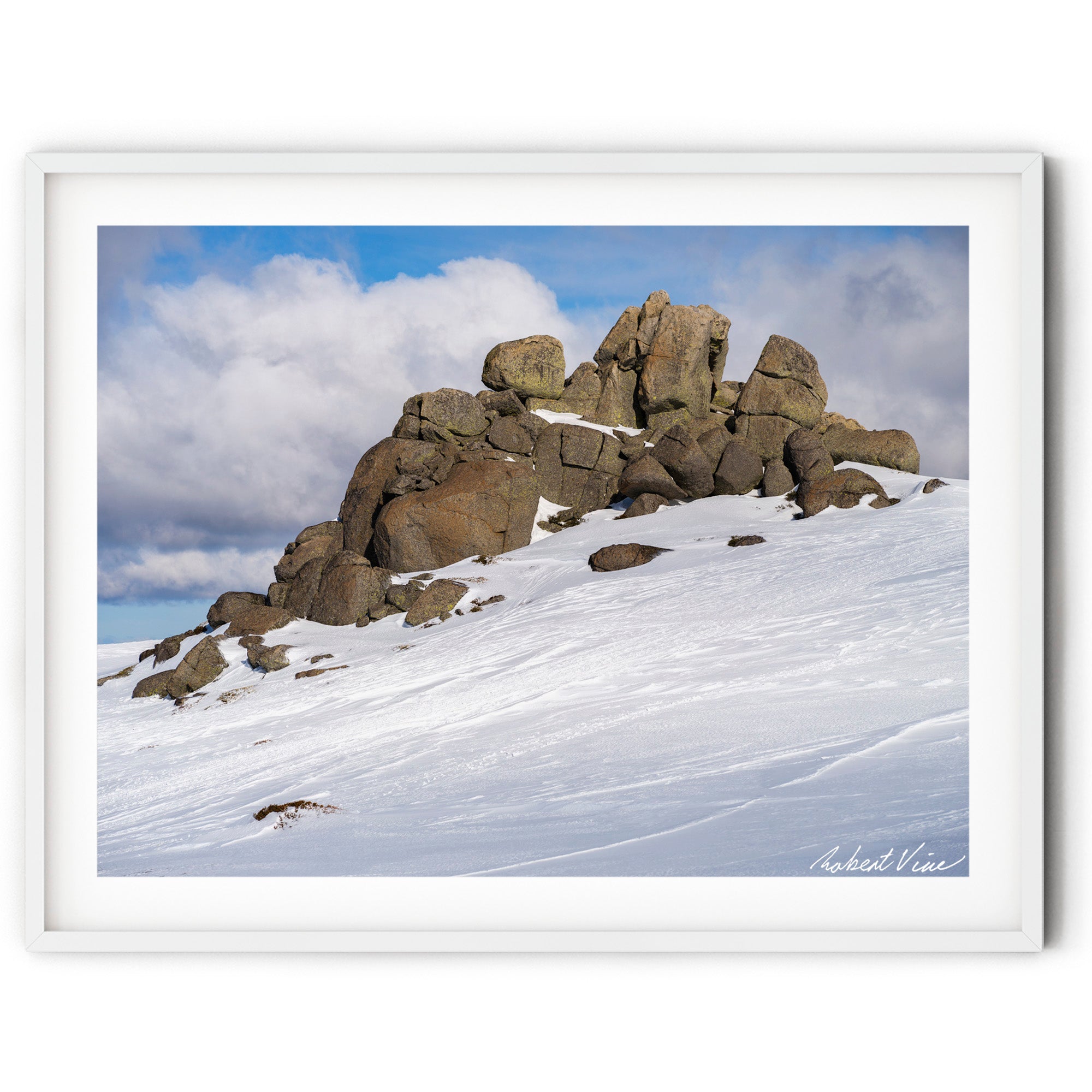 Framed wall art print of a Snow-covered granite rock formation at the summit of Thredbo beneath dramatic alpine clouds in the Snowy Mountains, photographed by Robert Vine.