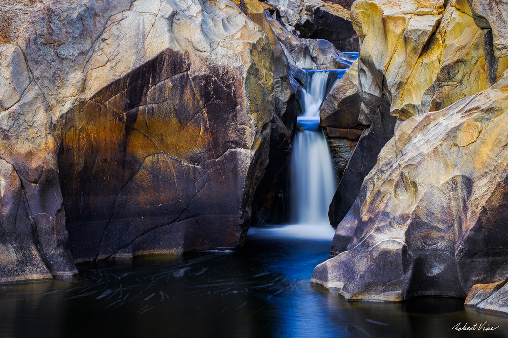 Long exposure photograph of a small waterfall flowing through sculpted granite rock formations at Googong Cascades, captured by Robert Vine.