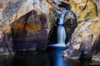 Long exposure photograph of a small waterfall flowing through sculpted granite rock formations at Googong Cascades, captured by Robert Vine.