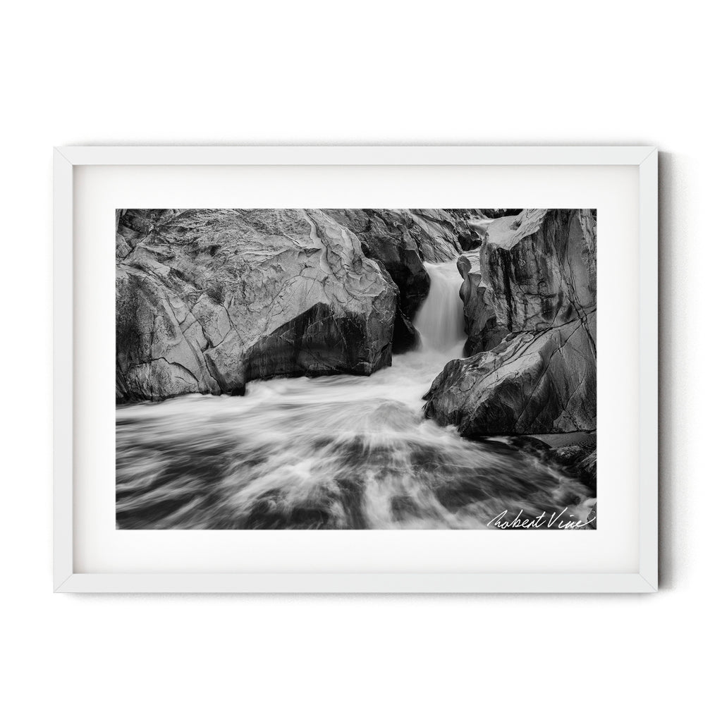 Framed black and white photograph of flowing water cascading through sculpted granite rocks at the Googong Cascades, captured by Robert Vine.