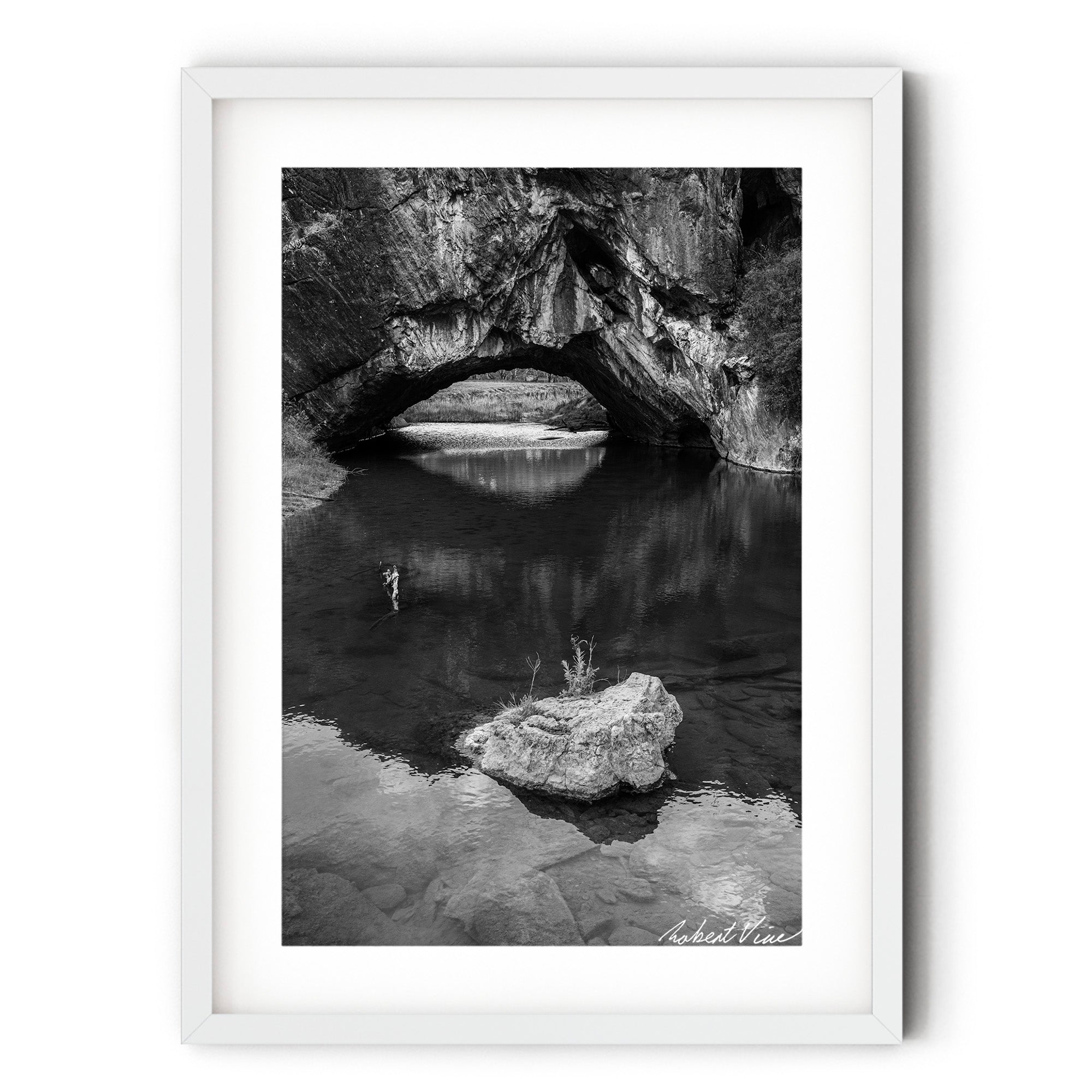 Frame print of Black and white photograph of London Bridge at Googong, NSW, reflected in calm water beneath the natural limestone arch by Robert Vine.